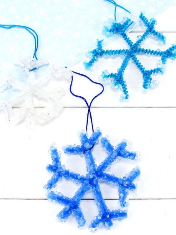 nopin="nopin" Sparkly blue and white snowflake ornaments with a white backdrop
