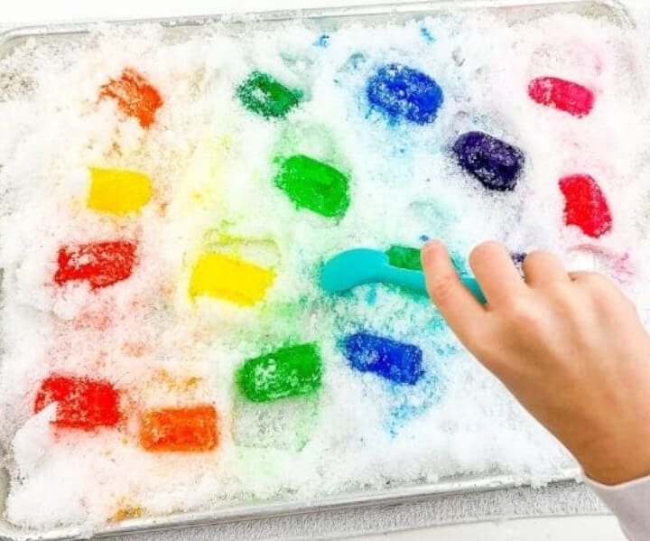 colored ice cubes in sensory bin for kids