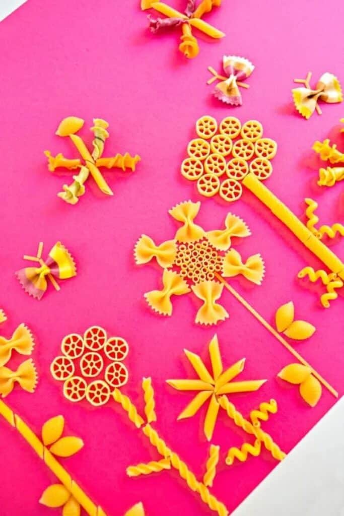 flowers made from pasta in various shapes on pink background